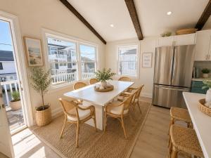a kitchen and dining room with a white table and chairs at Mermaid Manor in Brighton Beach
