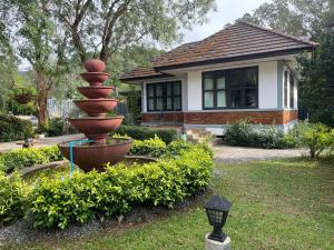 a garden with a statue in front of a house at IYARA b in Ban Map Khangkhao +16 photos