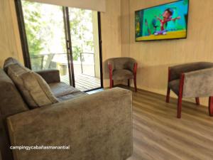 a living room with a couch and two chairs at cabañasmanantialpanguipulli in Panguipulli +10 photos