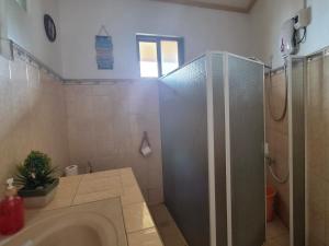a bathroom with a shower and a toilet and a sink at Danao RM House in Idanao +16 photos