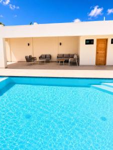 a house with a swimming pool in front of it at Modern Villa 2 BR Near Airport, Beaches, Dining in Punta Cana