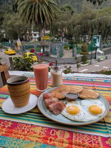 a plate of eggs and bacon on a table at Crater Eruption Backpacker Hostel in Baños +35 photos