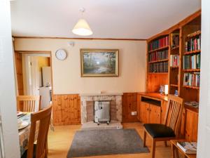a living room with a fireplace and a table and chairs at Forest View in Teeranearagh