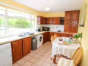 a kitchen with a table and a sink and a window at Forest View in Teeranearagh