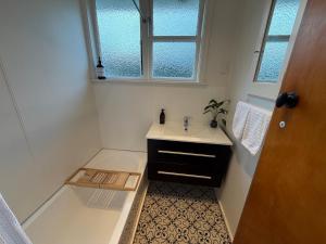 a bathroom with a sink and a bath tub at Tyne above Town in Oamaru +12 photos