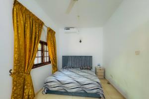 a bedroom with a bed and a window at Senu Bungalow in Ragama