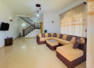 a living room with a couch and a tv at Senu Bungalow in Ragama