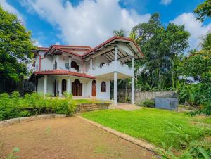 a white house with a red roof at Senu Bungalow in Ragama