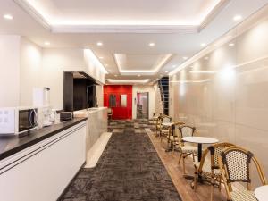 a kitchen with chairs and a table in a room at Hotel Neo Rouge in Tokyo