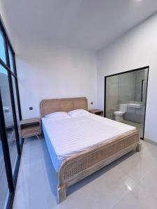 a bedroom with a large bed and a bathroom at Poshaka Karimunjawa in Karimunjawa