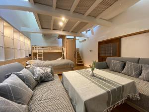 a living room with two couches and a bunk bed at 蔵Mping Hotel in Fukaya