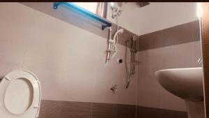 a bathroom with a shower and a toilet and a sink at Cili Hotel & Pizza Restaurant in Arugam Bay