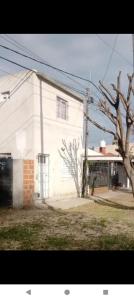 a white building with a tree in front of it at Duplex con cochera in Paraná