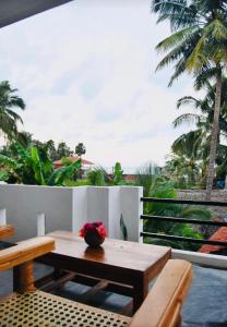 a patio with a wooden table with flowers on it at Cili Hotel & Pizza Restaurant in Arugam Bay