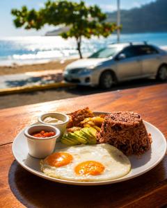 a plate of food with eggs and bread on a table at Hotel Ocean View in San Juan del Sur
