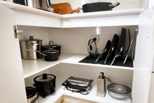a kitchen with some utensils on a shelf at Smugglers Cove in Esperance