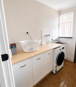 a kitchen with a washer and dryer on a counter at Smugglers Cove in Esperance