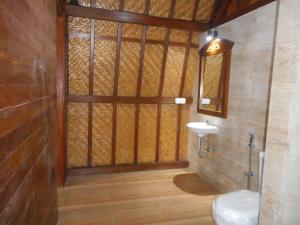 a bathroom with a wooden door and a sink at Artala Villa & Restaurant in Besakih