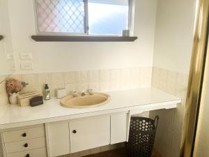 a bathroom with a sink and a window at Smugglers Cove in Esperance