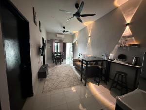 a living room with a ceiling fan and a table at Aden's Stopover House in Kuala Nerang