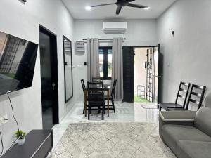 a living room with a couch and a table and chairs at Aden's Stopover House in Kuala Nerang