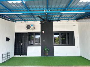 a building with a blue ceiling and a fan at Aden's Stopover House in Kuala Nerang