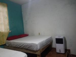 a small bedroom with two beds and a heater at hostal la playa vallarta in Puerto Vallarta