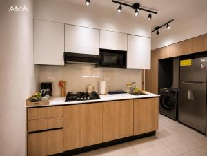 a kitchen with white cabinets and a stove top oven at Hermoso refugio céntrico in Santo Domingo