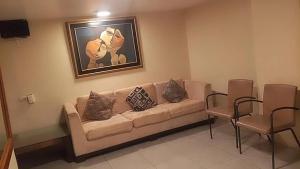 a living room with a couch and a painting on the wall at hotel rio in Guayaquil