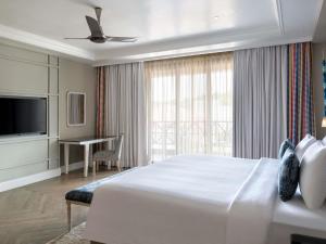 a bedroom with a large bed and a television at Grand Mercure Goa Candolim - An Accor Hotels Brand in Candolim