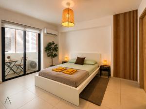 a bedroom with a bed with two orange pillows on it at Hermoso refugio céntrico in Santo Domingo +40 photos