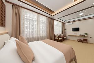 a hotel room with a bed and a television at Dali Classical Rosewood Boutique Inn in Dali