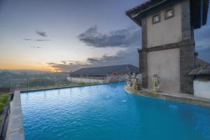 a swimming pool with a hose in the water at Nirmala Heritage Hotel in Jimbaran