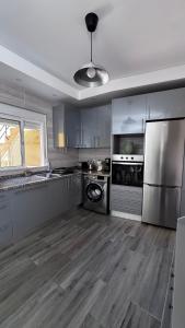 a large kitchen with stainless steel appliances and wooden floors at Zen Terrace Townhouse in Faro