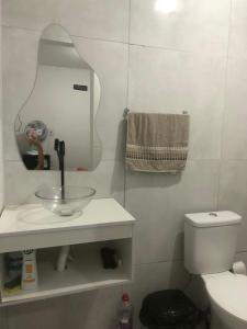 a bathroom with a sink and a mirror and a toilet at Pousada da Neném - Quarto Tangerina in Campina Grande +9 photos