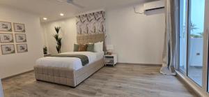 a bedroom with a bed and a large window at Nala Host - Maafushi Homes in Maafushi