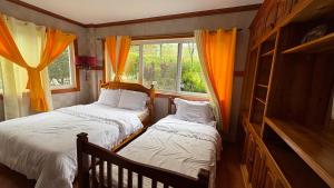 a bedroom with two beds and a window at Lot12-A1F,Forest Estate,Campjohnhay in Baguio