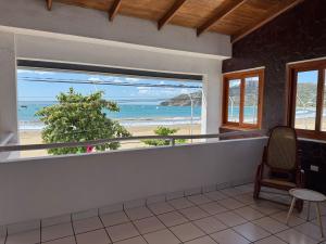a room with a balcony with a view of the beach at Hotel Ocean View in San Juan del Sur