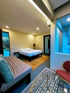 a bedroom with two beds and a tv in it at The Ronin in General Luna