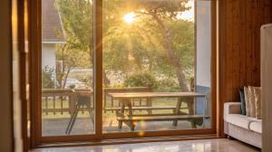 a sliding glass door with a table and a bench outside at Daebu-do, White Island Pension in Ansan