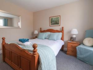 a bedroom with a large bed and a mirror at Bluebell Cottage in Selby