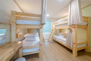 two bunk beds in a room with at Visitor guesthouse in Jeju