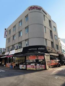a building on a street with a vittoria visitor at Visitor guesthouse in Jeju
