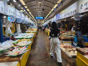 a woman is walking through a fish market at Visitor guesthouse in Jeju