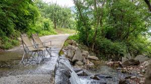 two chairs sitting on a road next to a river at Sara&Forest Pension Mungyeong in Mungyeong