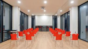 an empty conference room with red chairs and a projection screen at Sara&Forest Pension Mungyeong in Mungyeong