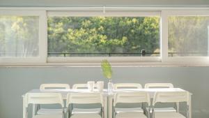 a white table with white chairs and a window at Sara&Forest Pension Mungyeong in Mungyeong