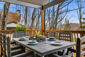 a table on a deck with chairs on a porch at The Four Seasons Escape in Pocono Lake