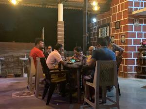 a group of people sitting at a table in a restaurant at Samarpit Guest House in Devgarh