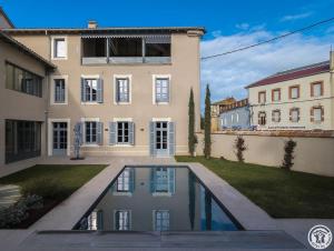a house with a swimming pool in front of it at La villa saviesa in Cazères